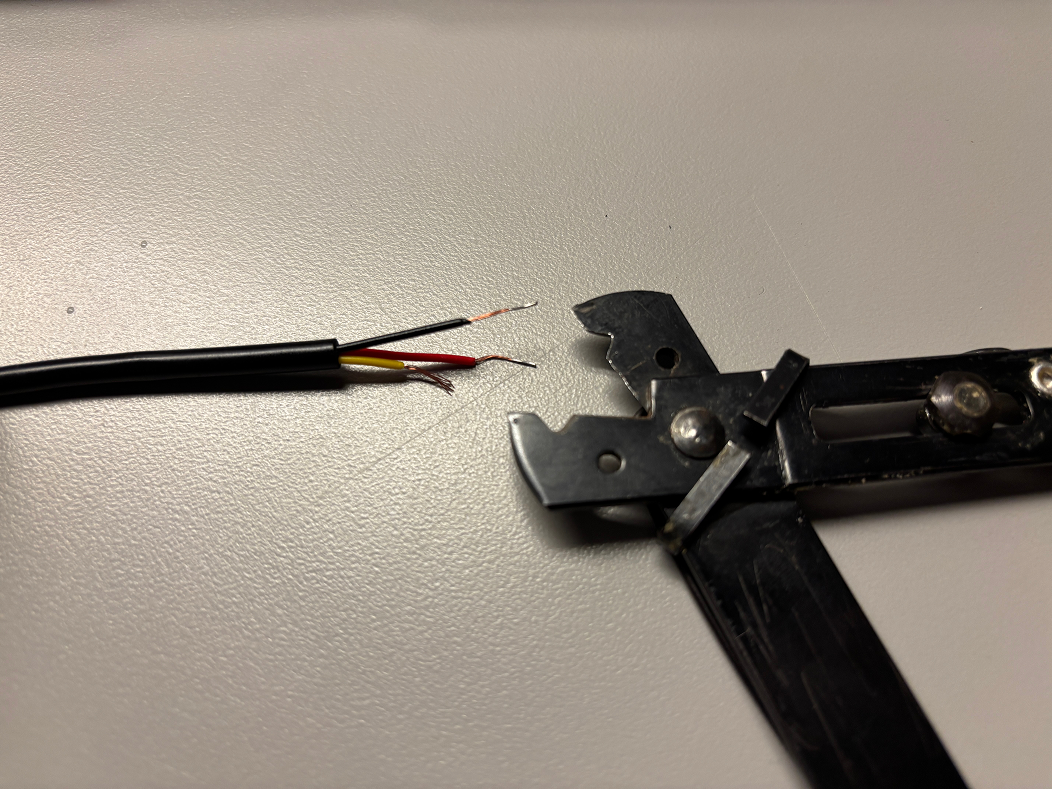 Stripping the wires attached to the DS18B20 Temp Sensor. These wires were much thinner than regular copper wires, and so we had difficulties stripping it without the wires getting frayed. 